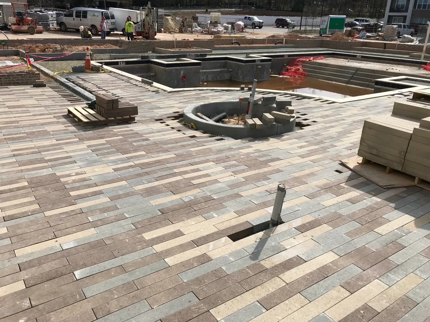 Commercial paver courtyard installation with hardscape layout and planting beds, view 1