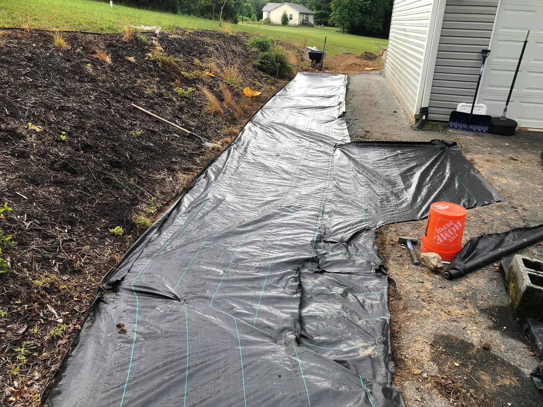 Base preparation and fabric layout for natural stone patio work, view 1