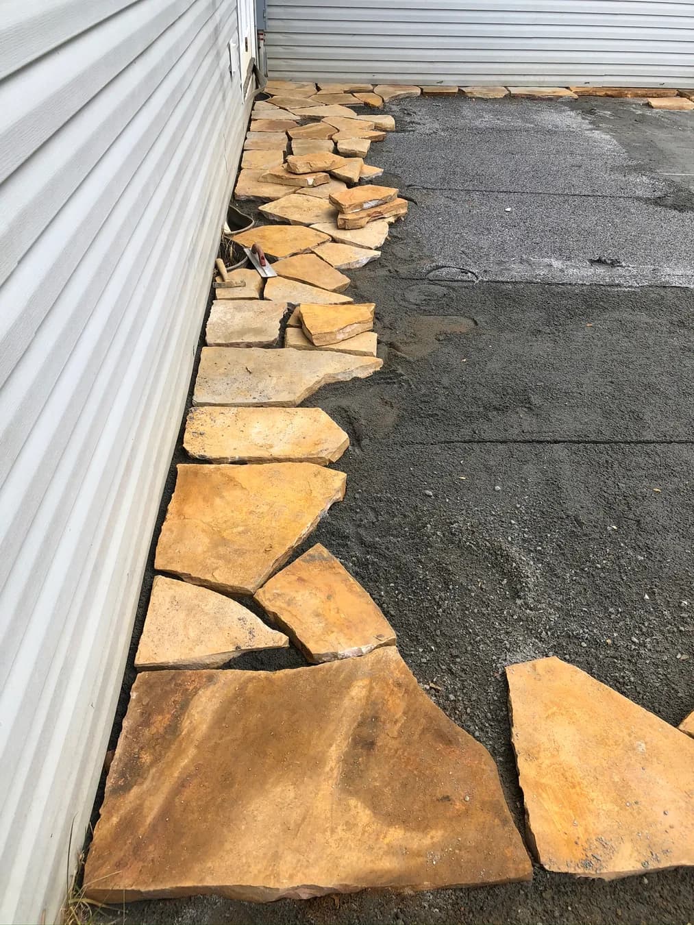 Natural stone edge fitment beside the prepared patio base, view 5
