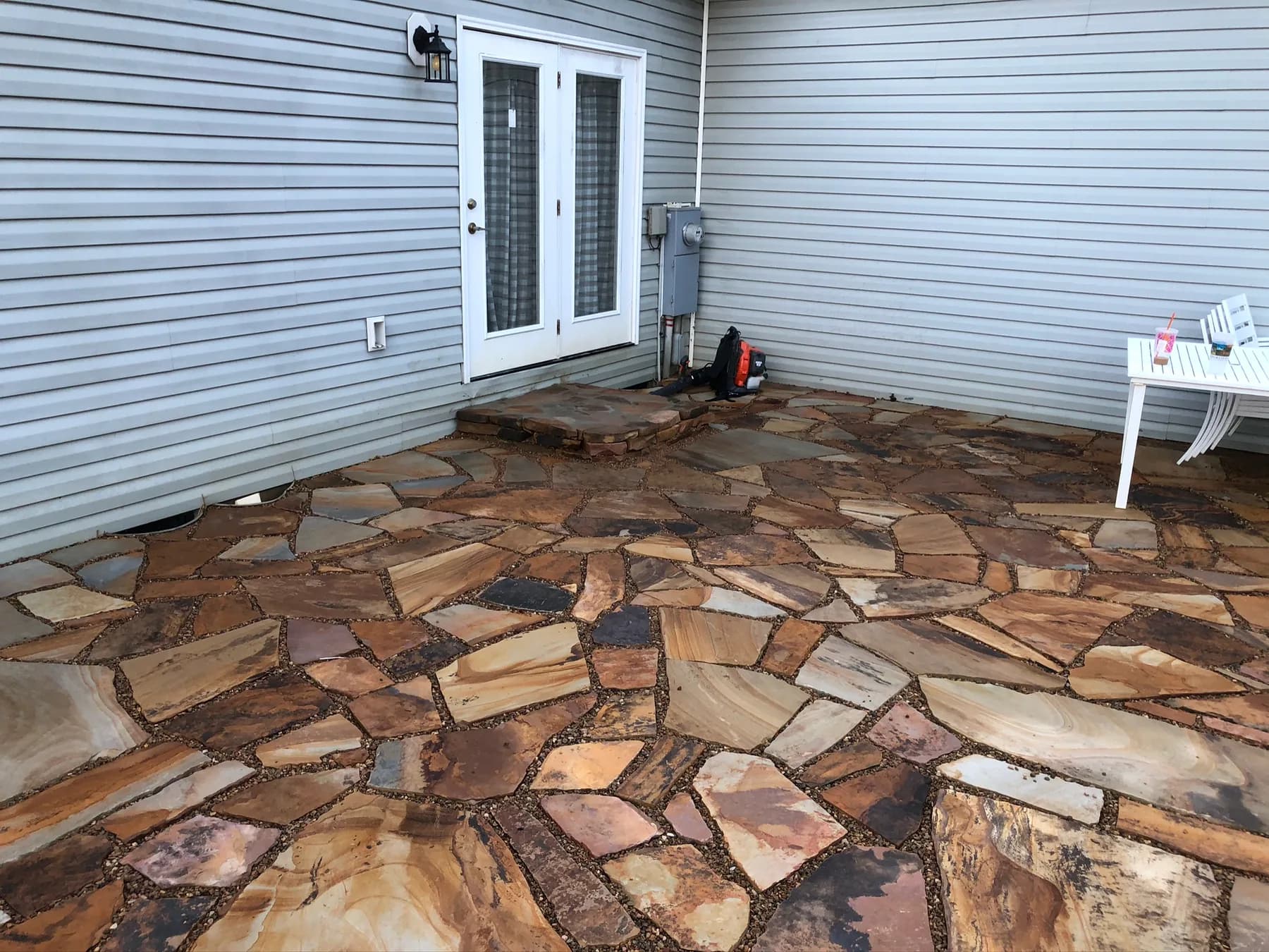 Finished natural stone patio surface and foundation-edge transition, view 9
