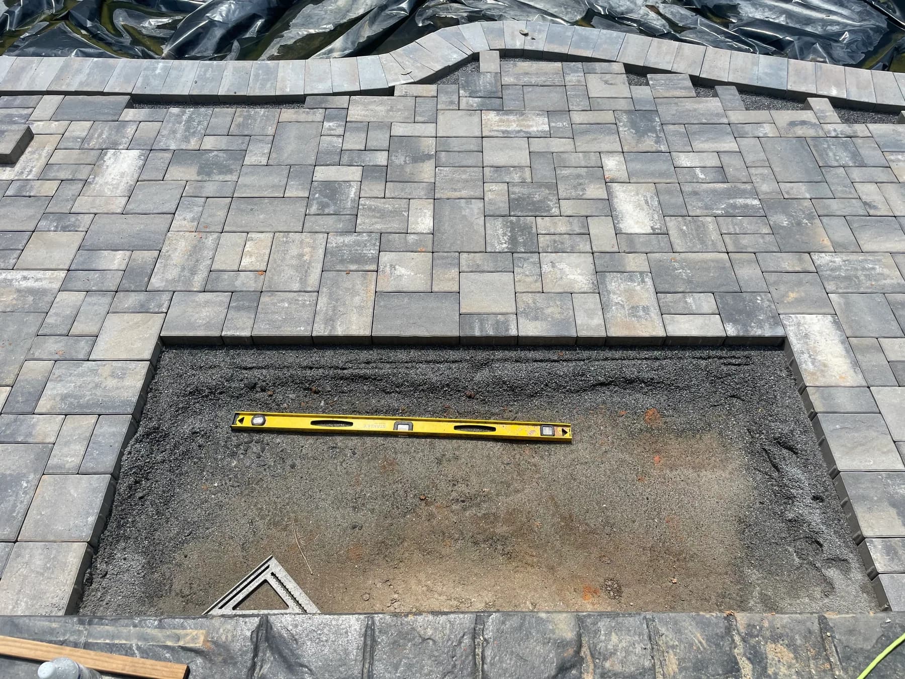 Poolside paver deck installation with border course and curved pool edge, view 9