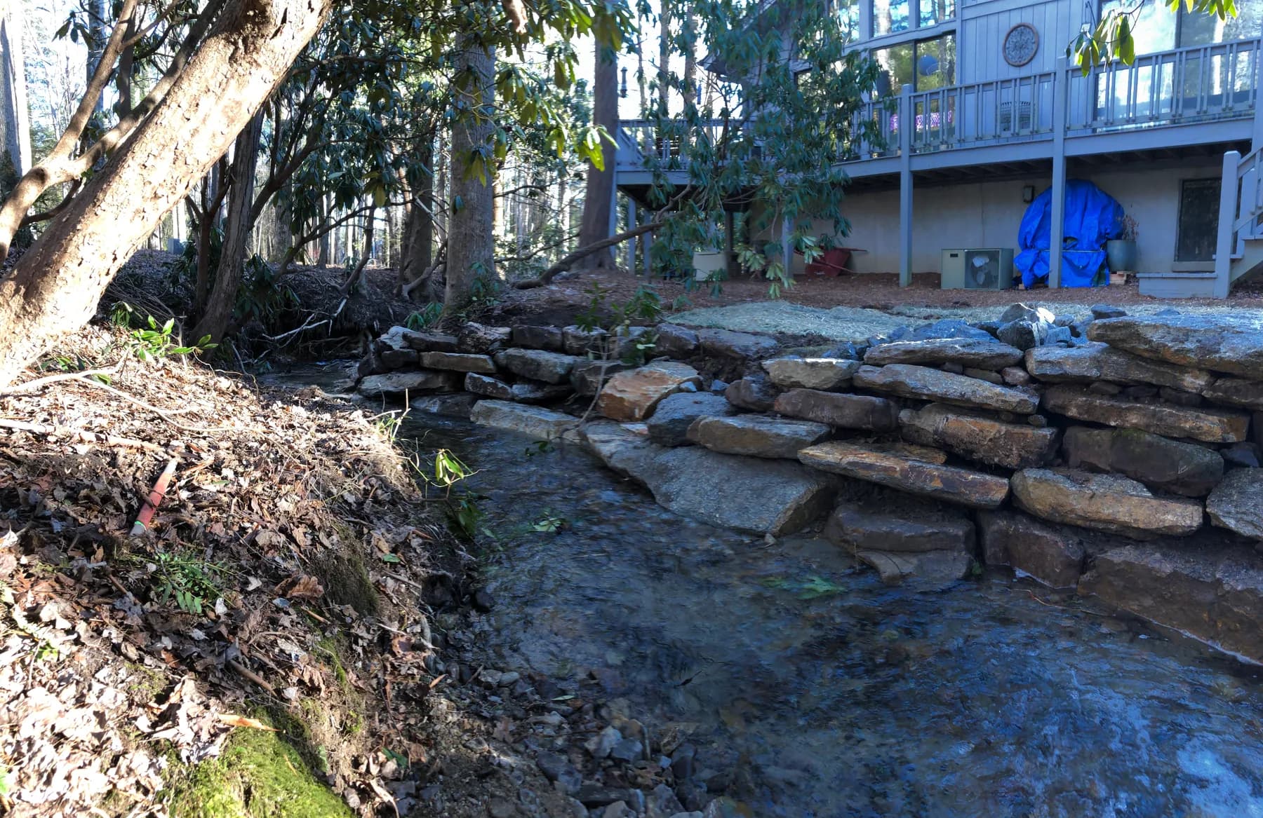 Natural stone placement along a riverbank edge for erosion control, view 2