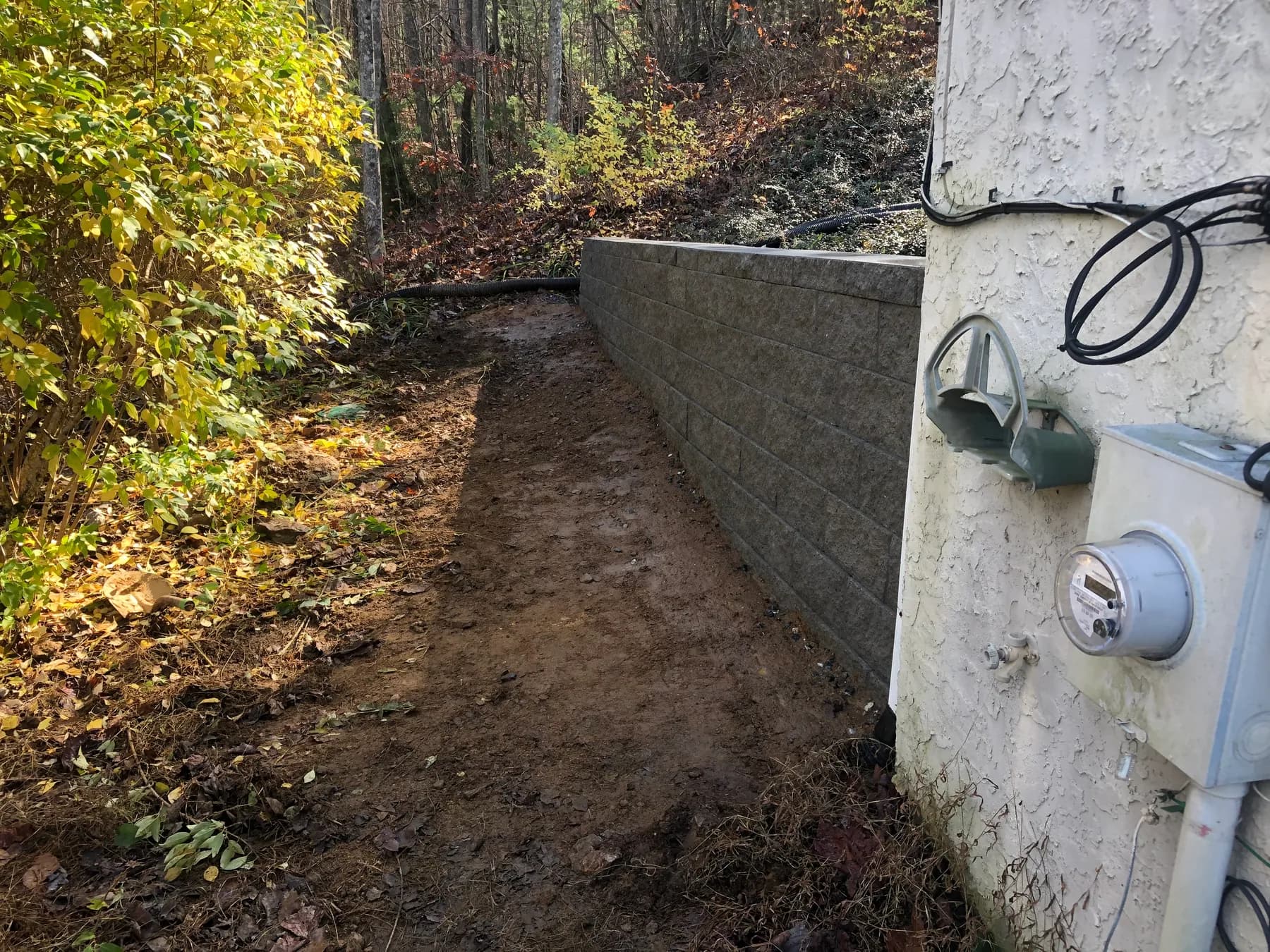 Finished segmental retaining wall along a wooded grade transition, view 3